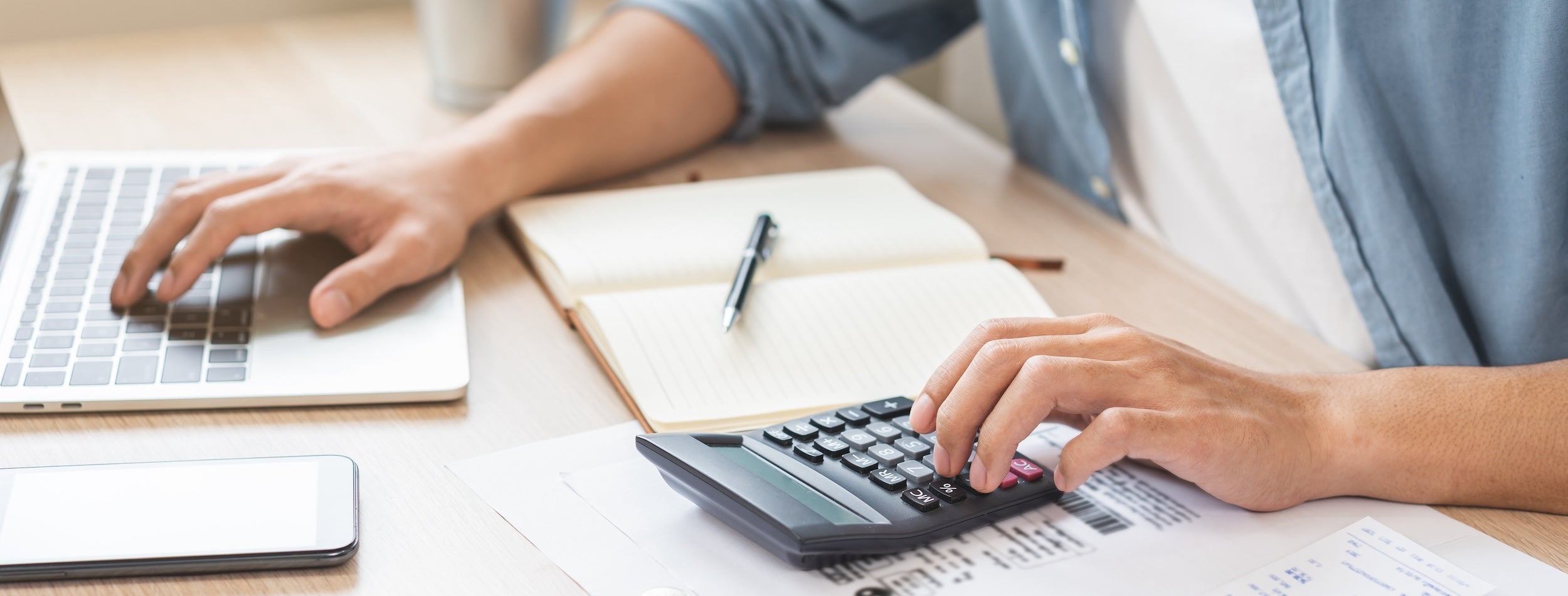 homeowner using calculator to add up budget costs
